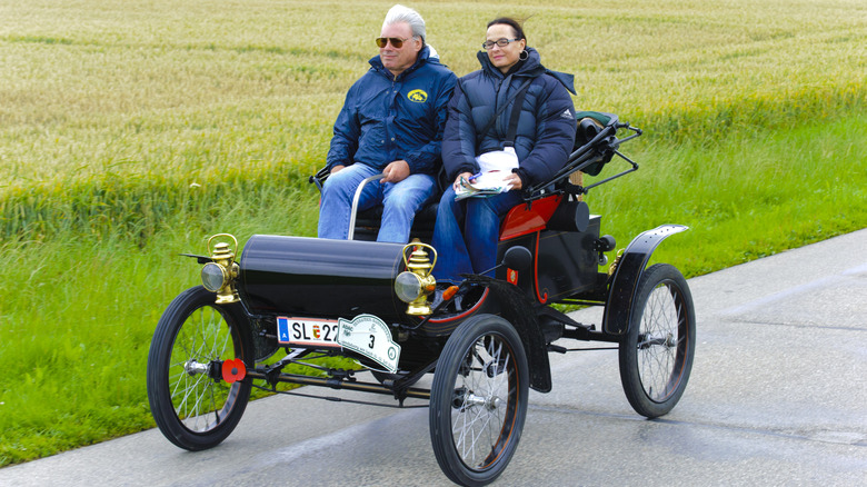 Two riders cruise in Curved Dash Oldsmobile