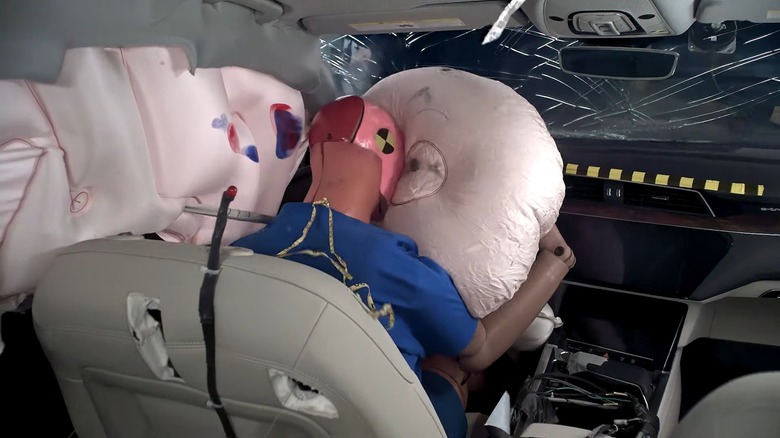A crash test dummy during a collision with airbags deployed