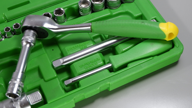 Green handled ratchet wrench with attached long socket
