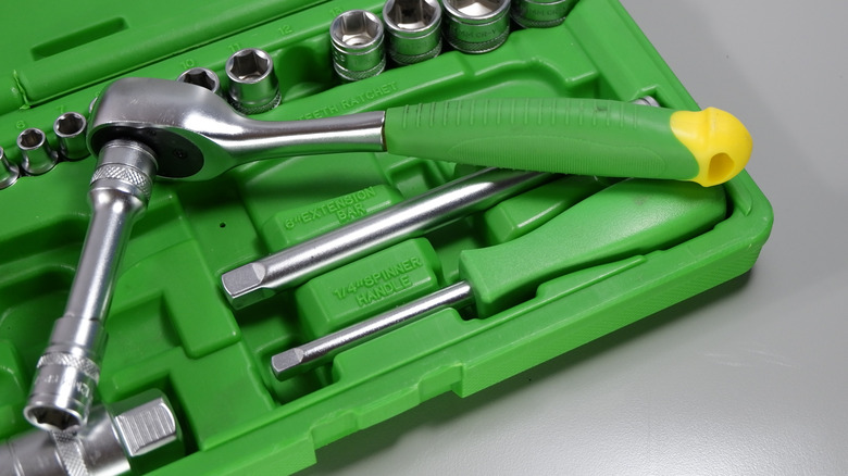 Green handled ratchet wrench with attached long socket