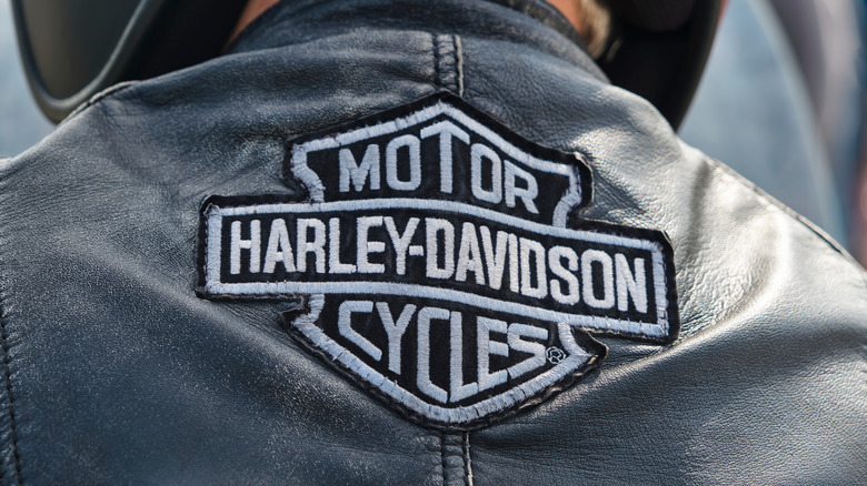 Person wearing leather jacket with Harley-Davidson logo