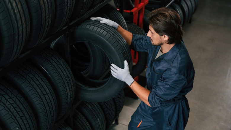 Tire technician selecting a tire in tire store