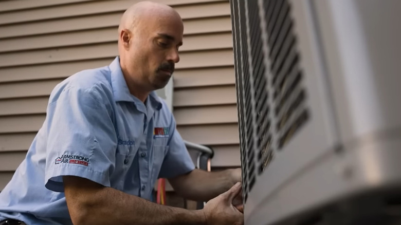 Armstrong Air repair man installing AC