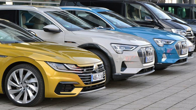 Audi and Volkswagen cars parked side by side in a street in Europe