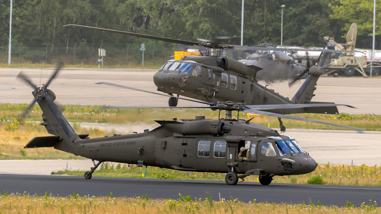 A pair of UH-60M Sikorsky Black Hawk helicopters taking off for a routine mission.