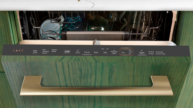 Café Appliances dishwasher with custom green wood front and gold handle slightly open to see a full top rack of dishes