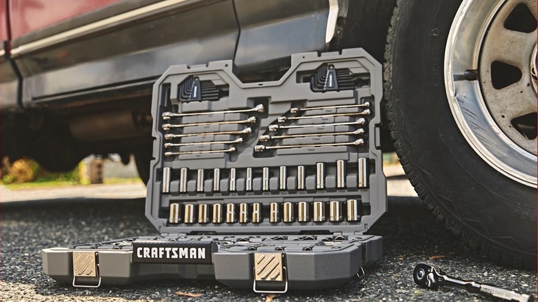 Craftsman socket set on asphalt near car wheel