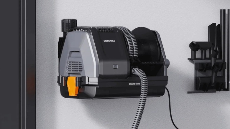 A Giraffe Tools vacuum cleaner attached to a wall.