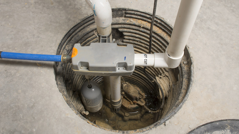 A new sump pump installed in a concrete basement floor