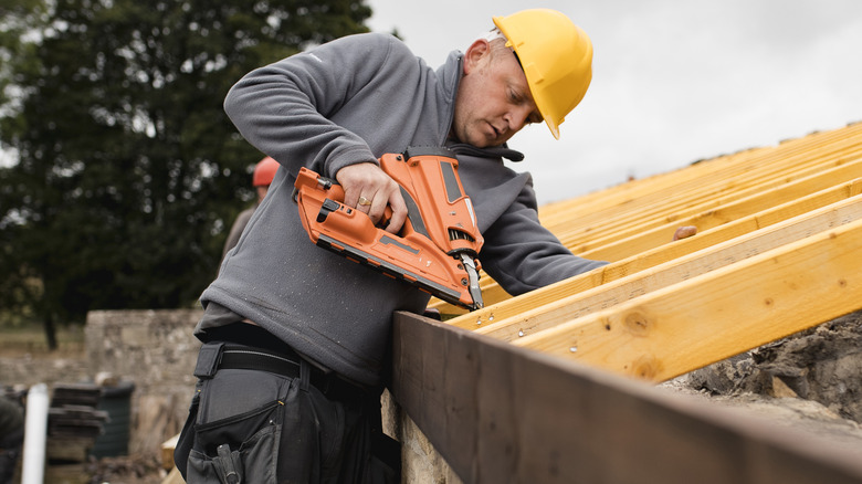 Worker using cordless nail gun