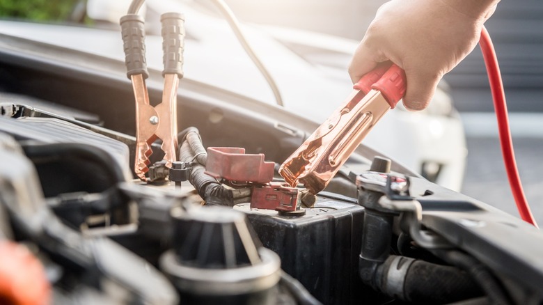 Jumper cables attached to car battery.