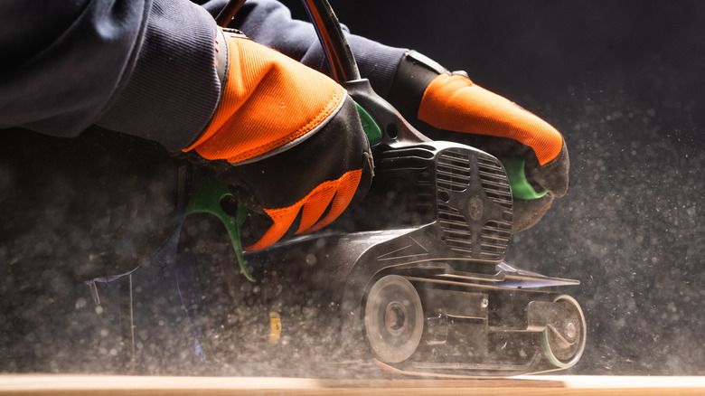 Person using belt sander