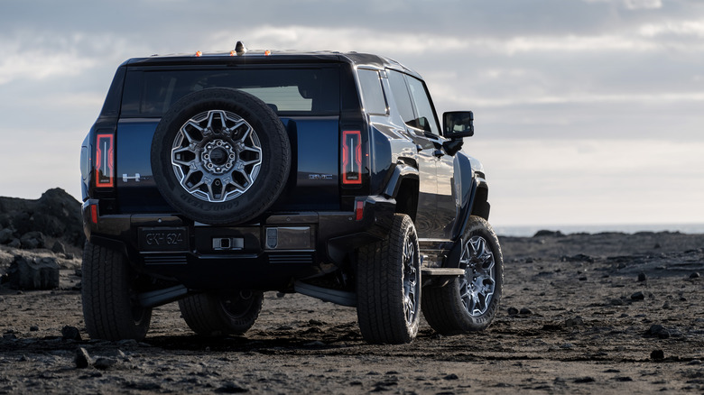 Rear 3/4 view of 2025 GMC Hummer EV SUV in sand