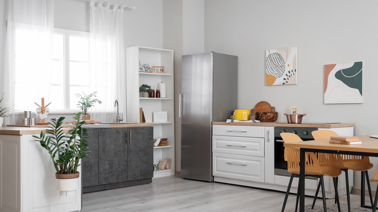 A kitchen in a small apartment with a single-door refridgerator in the corner