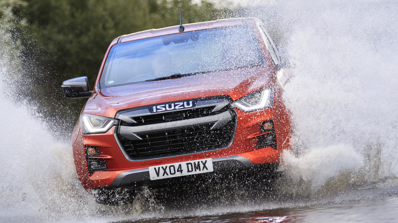 An orange 2021 Isuzu D-Max wadding through water