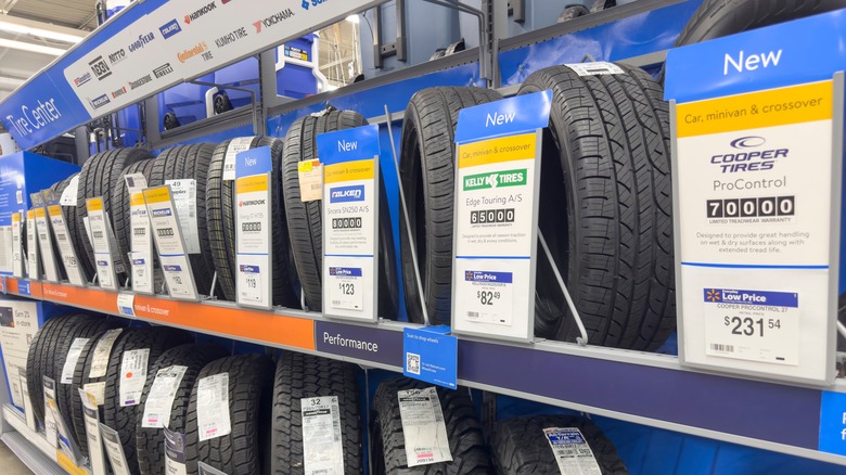 A stand in a tire shop showing Cooper, Kelly, and Falken tires on sale.