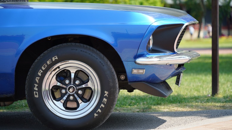 A side close-up of a blue muscle car with Kelly Charger tires on.