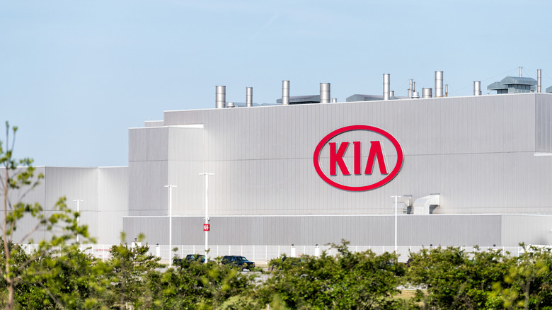 View of the Kia manufacturing plant with large 'Kia' logo on the facade.