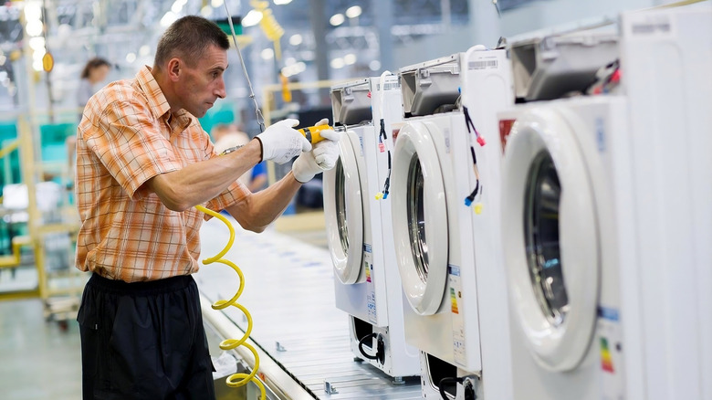 Person assembling an LG washer at its Poland facility