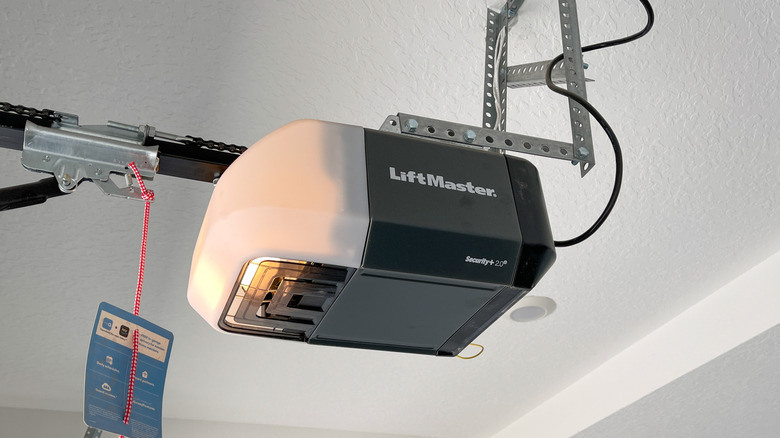 white, metal, and grey box mounted on a metal frame overhead. The word LiftMaster is written on the side