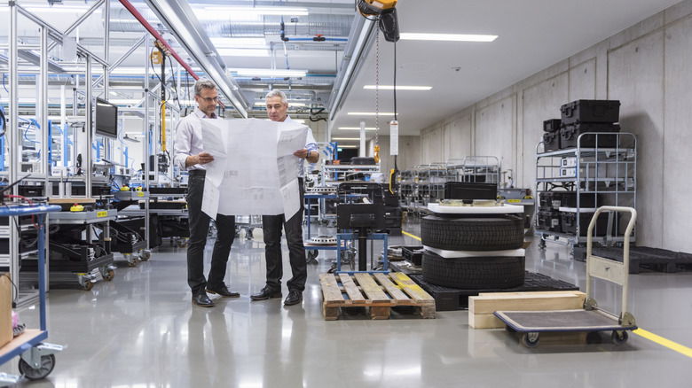 Two engineers having a discussion at a tire factory
