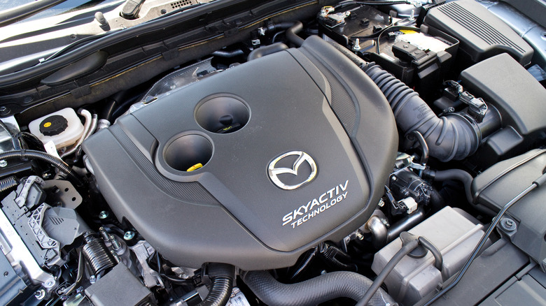Engine of a 2015 Mazda car with the hood up, during day time
