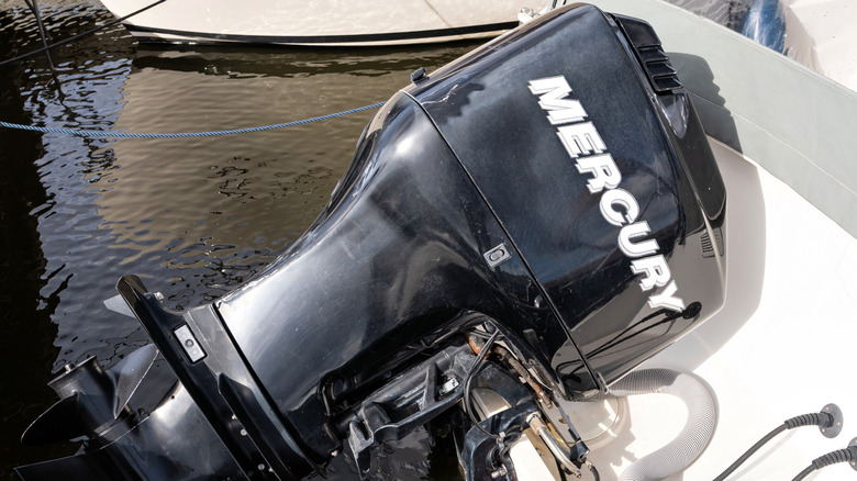 A close-up of a black Mercury four-stroke outboard motor on a docked boat