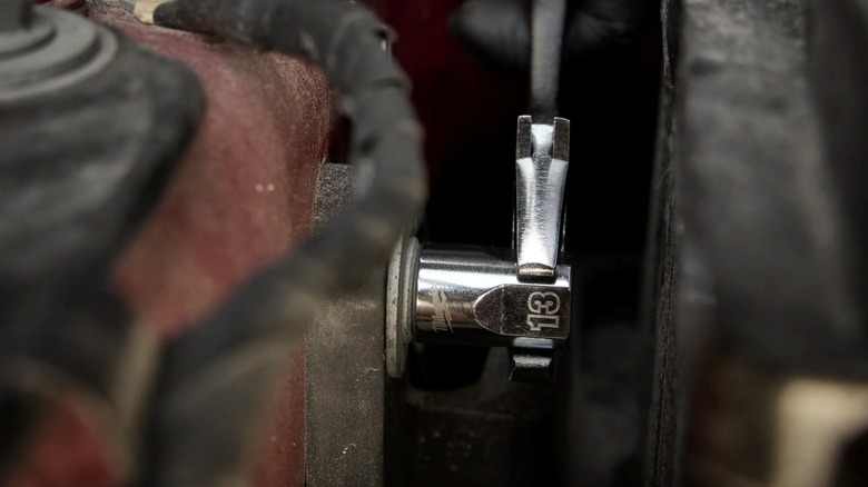 Using a wrench to turn a Milwaukee socket.