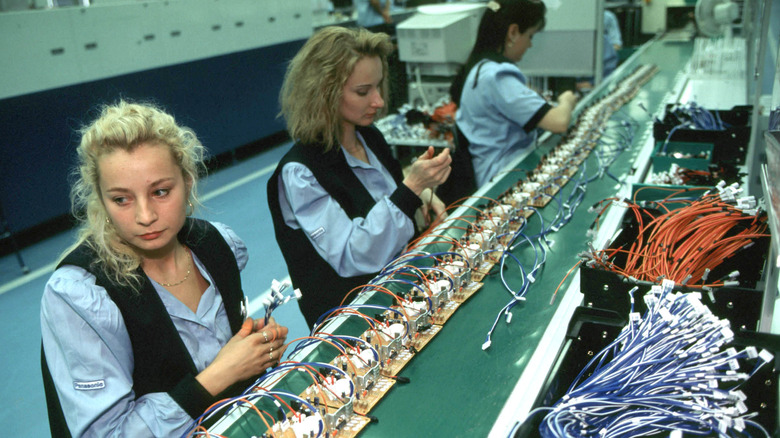 Asembly line at the Panasonic television factory, Pilsen, Czech Republic October 6th, 1997. Three women are shown assembling components by hand.
