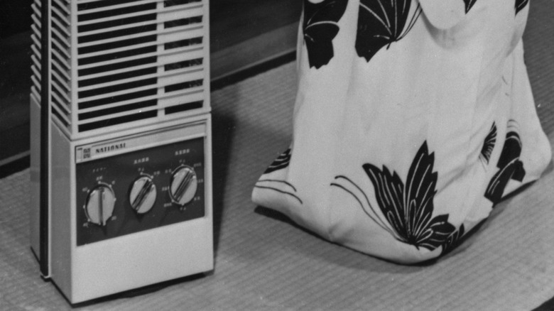 A cropped vintage advertising image showing a person in traditional Japanese dress next to a 1950s Panasonic fan