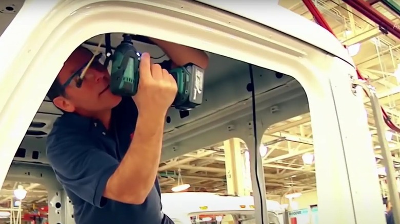 Man holding power tool and assembling Peterbilt truck