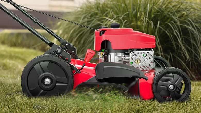 44cc gas push 2-in-1 red PowerSmart lawn mower on grass in front of a shrub.