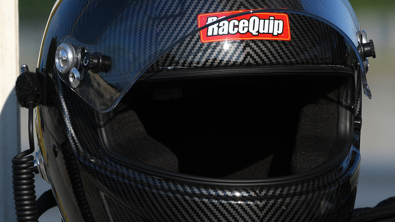 A close-up of a black RaceQuip helmet
