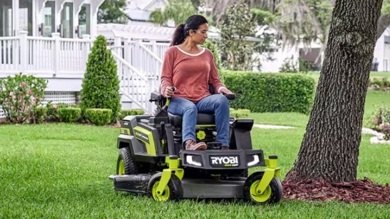 A woman mows her lawn with a Ryobi zero turn mower.