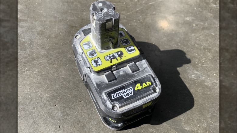 A dirty 4Ah Ryobi rechargeable 18-volt lithium battery.
