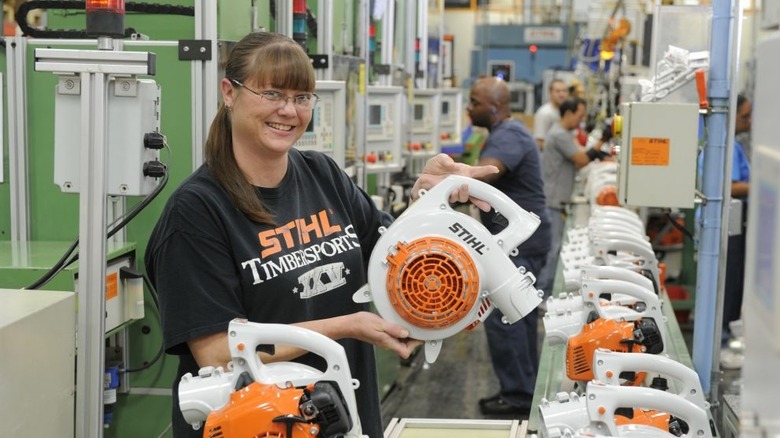 Worker showing STIHL product in manufacturing line