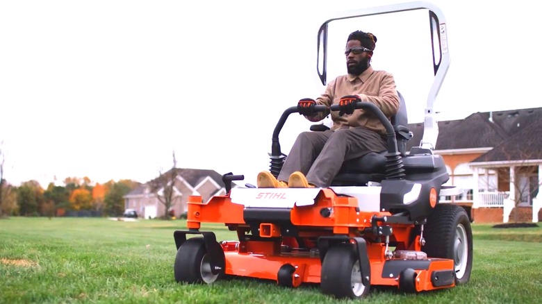 A Man Operating A STIHL Zero-Turn Mower Cutting A Residential Yard