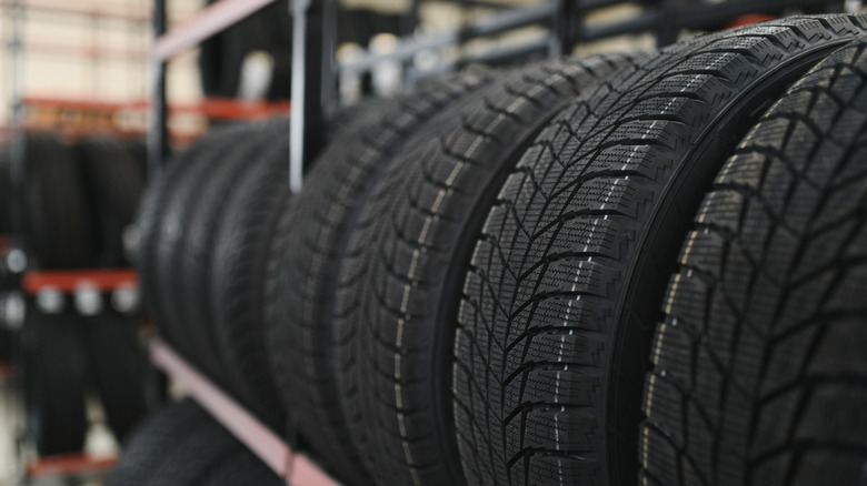 New car tires placed on a tire rack inside a shop.