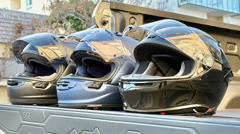 Three motorcycle helmets on the bed of a truck