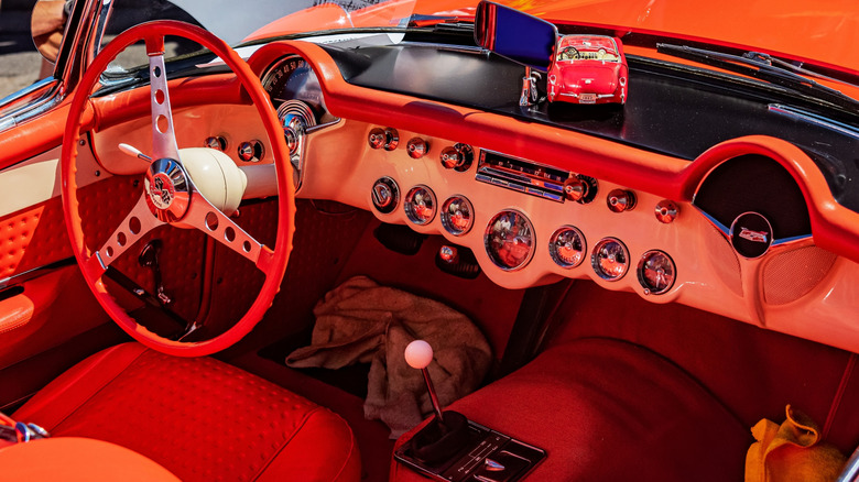 Interior view of red 1957 Corvette showing four-speed manual shifter.