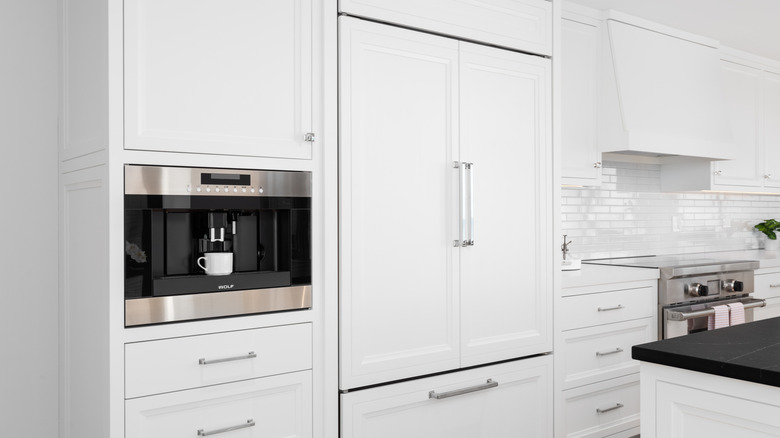 A high-end kitchen featuring a Wolf refrigerator and coffee maker.