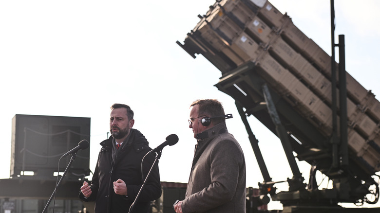 German Defense Minister and Polish Defense Minister standing near Patriot missile system