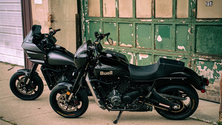 Two black Buell motorcycles against green wall