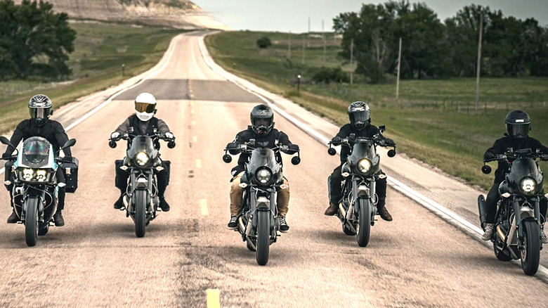 Group of people riding Buell Motorcycles on empty road