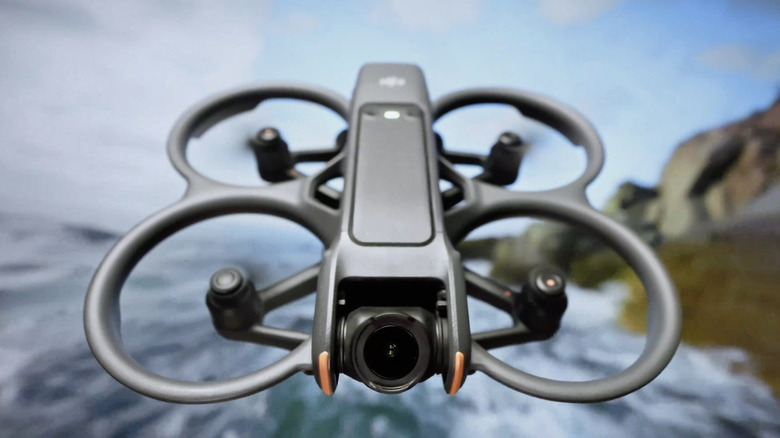The DJI Avata 2 flies against a scenic backdrop