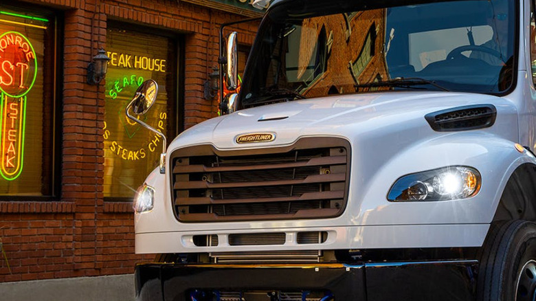 Freightliner M2 106 Plus truck on road near restaurant