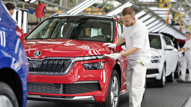 Škoda Kvasiny plant assembly line with technicians inspecting completed vehicles