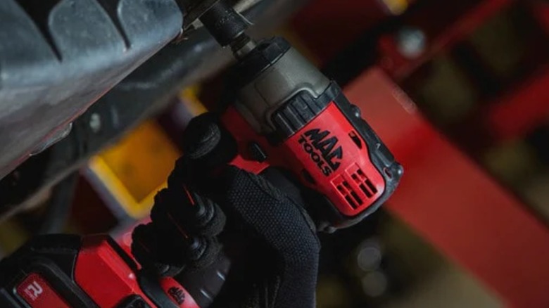 A person using a Mac Tools drill.