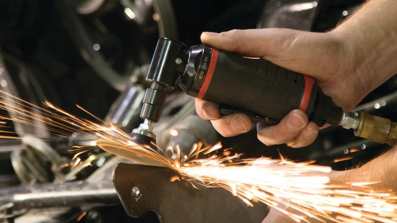 A person using a Mac Tools die grinder.