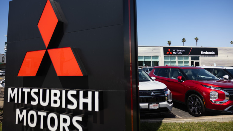 Mitsubishi dealership showing logo display with new vehicles on the lot, sign on dealership reading "Redondo"